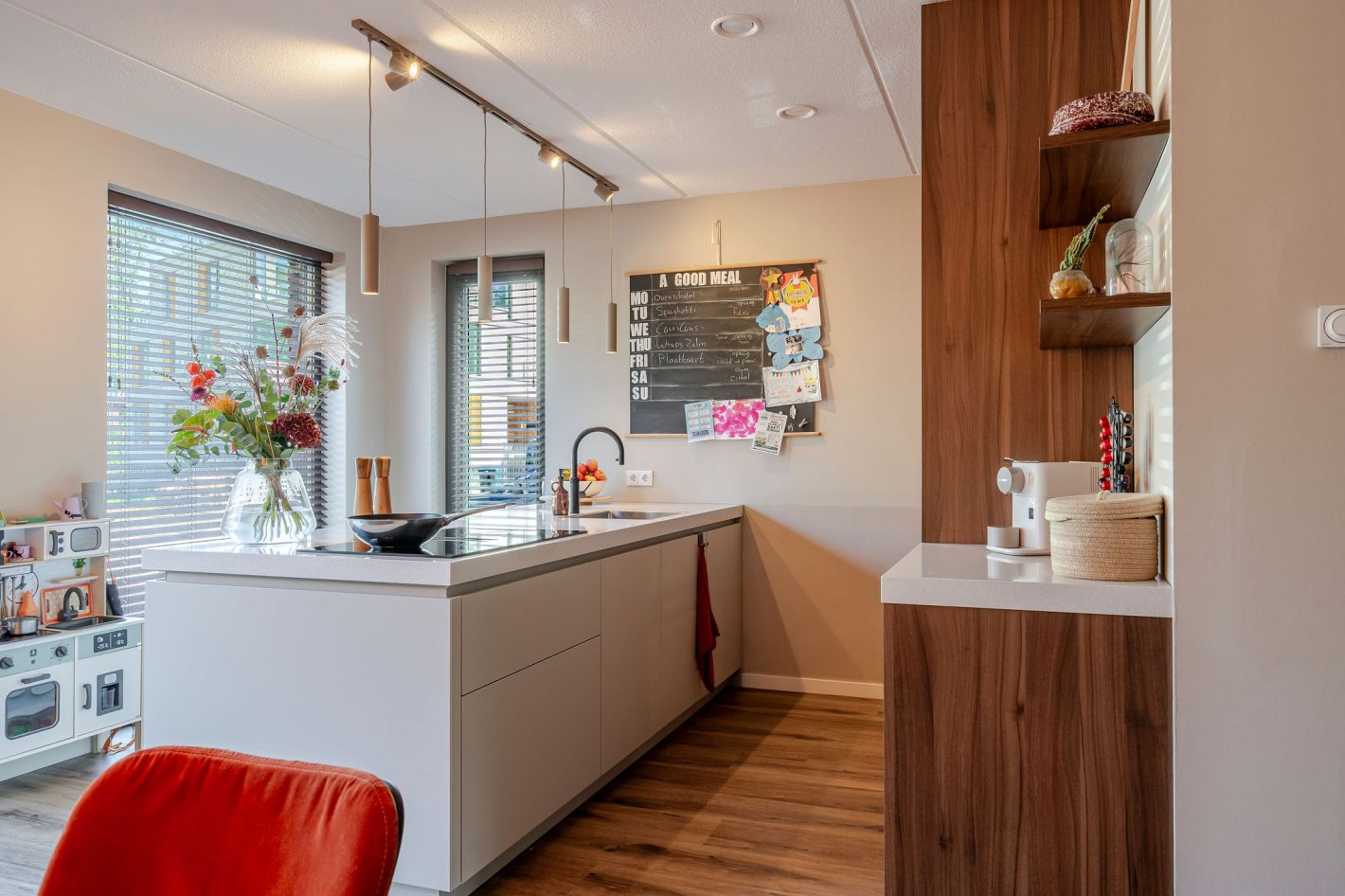Een sfeervolle keuken met licht kookeiland en houten kastenwand