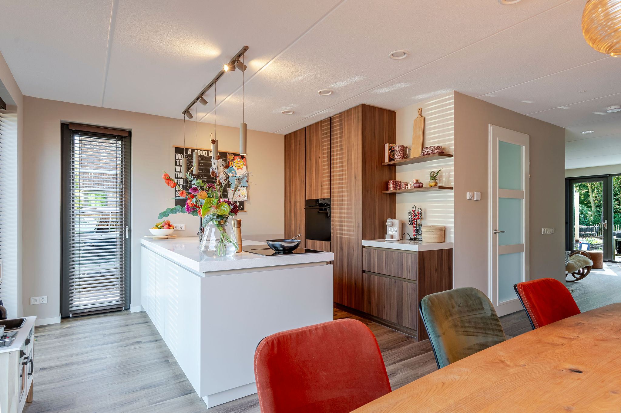 Een sfeervolle keuken met licht kookeiland en houten kastenwand