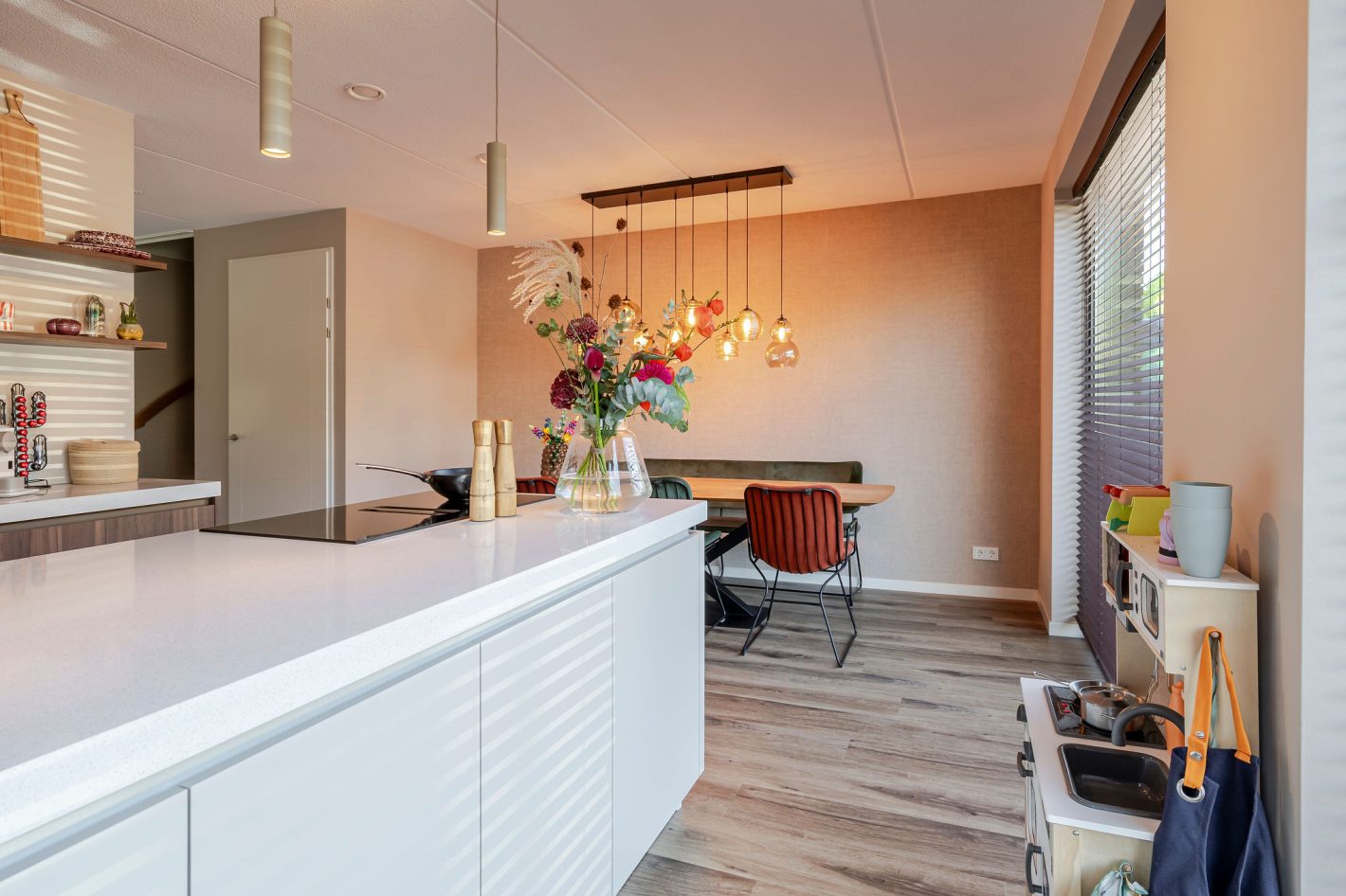 Een sfeervolle keuken met licht kookeiland en houten kastenwand