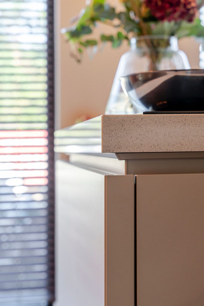 Een sfeervolle keuken met licht kookeiland en houten kastenwand