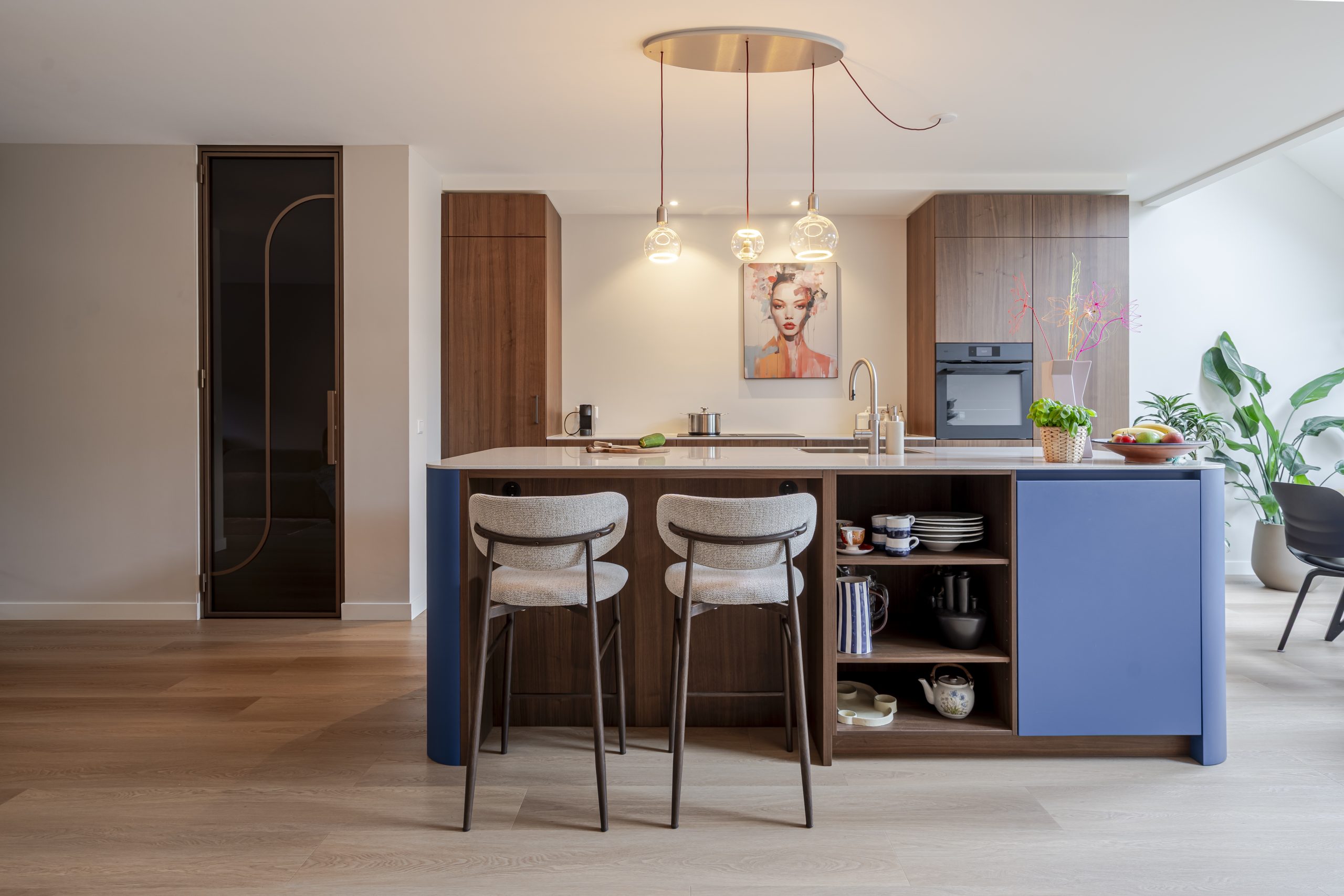 Blauwe keuken met houtlook en afgerond kookeiland