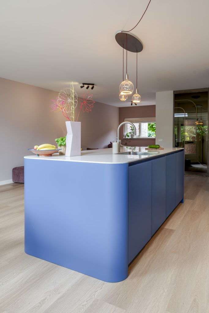 Blauwe keuken met houtlook en afgerond kookeiland