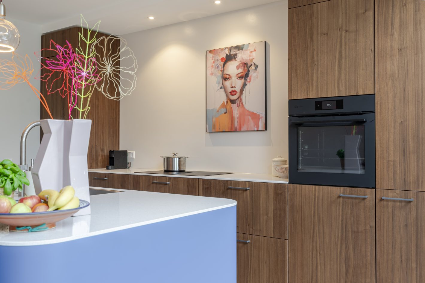 Blauwe keuken met houtlook en afgerond kookeiland
