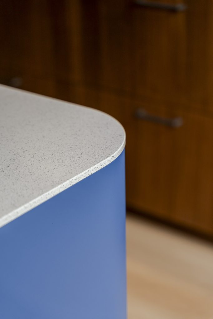 Blauwe keuken met houtlook en afgerond kookeiland
