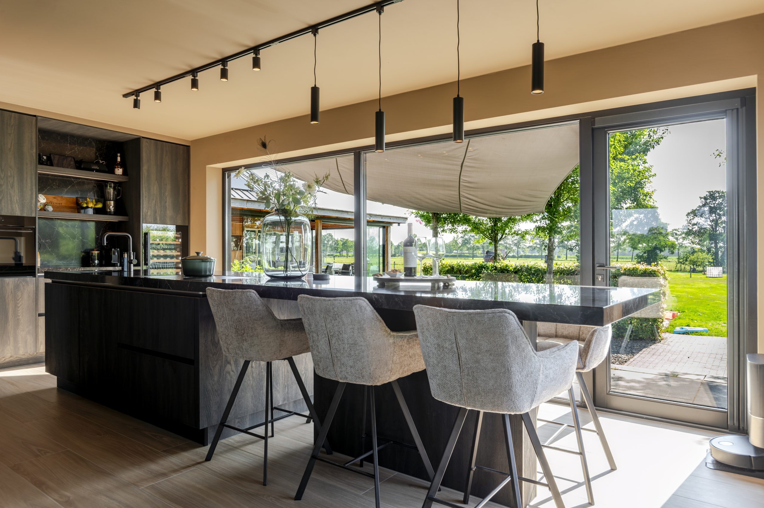 Een ruime leefkeuken met groot eiland en vaste eettafel