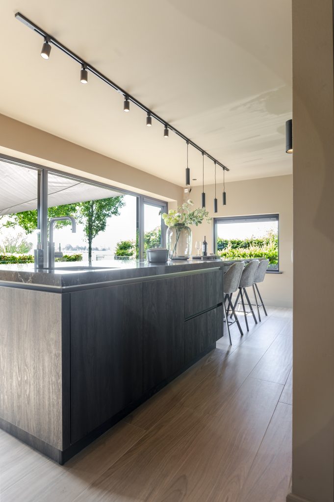 Een ruime leefkeuken met groot eiland en vaste eettafel